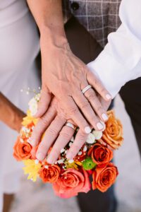 The bride and groom's wedding rings lit by sunset during a Tybee Island wedding experience.