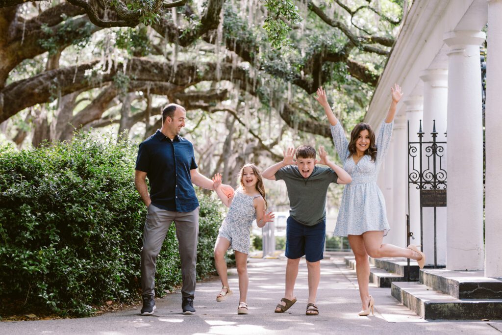 A family acts silly together near Forsyth Park's Fragrant Garden.