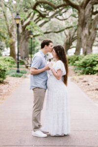 A couple shares a kiss in Forsyth Park.