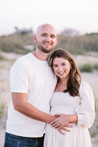 A man kisses his wife during maternity photos on Tybee Island.